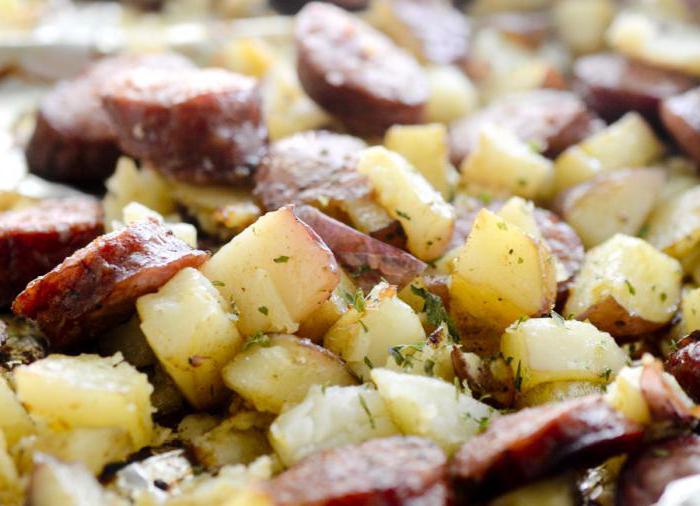 Sabroso plato - patatas con salchichas en el horno